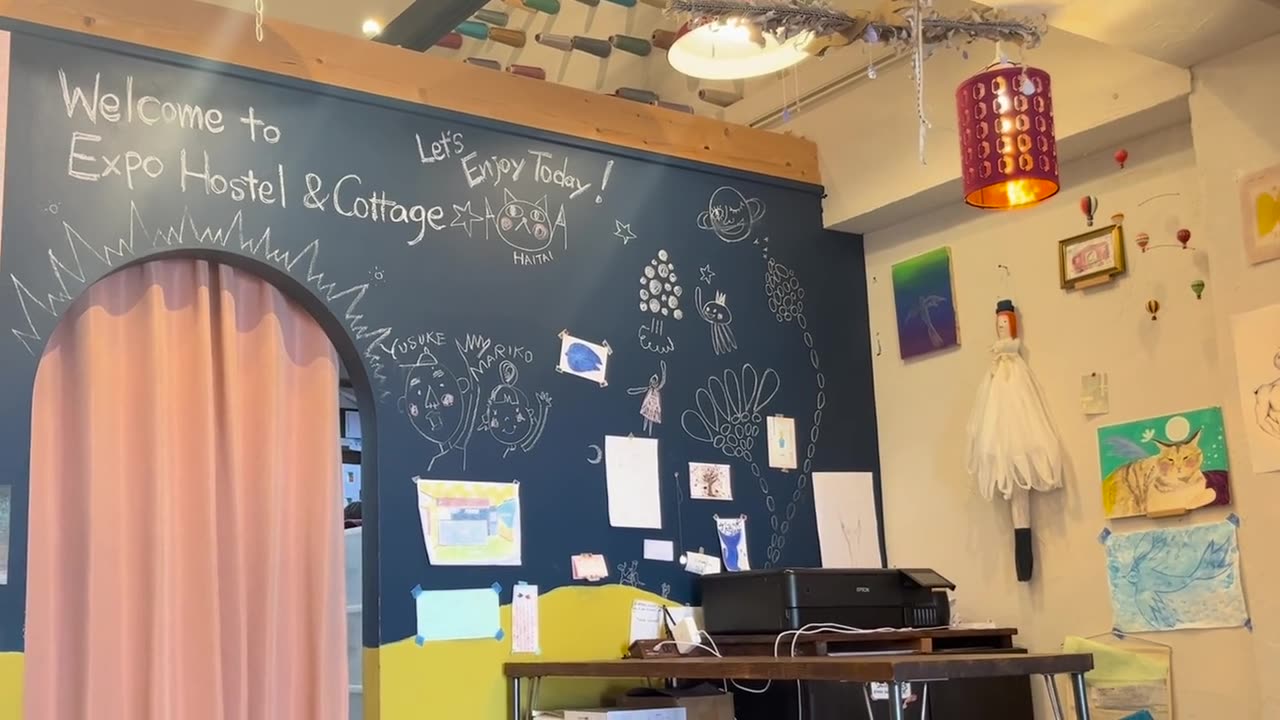 Our check-in office in Nishijin, with a chalkboard wall that says “Welcome to Expo Hostel & Cottage”
