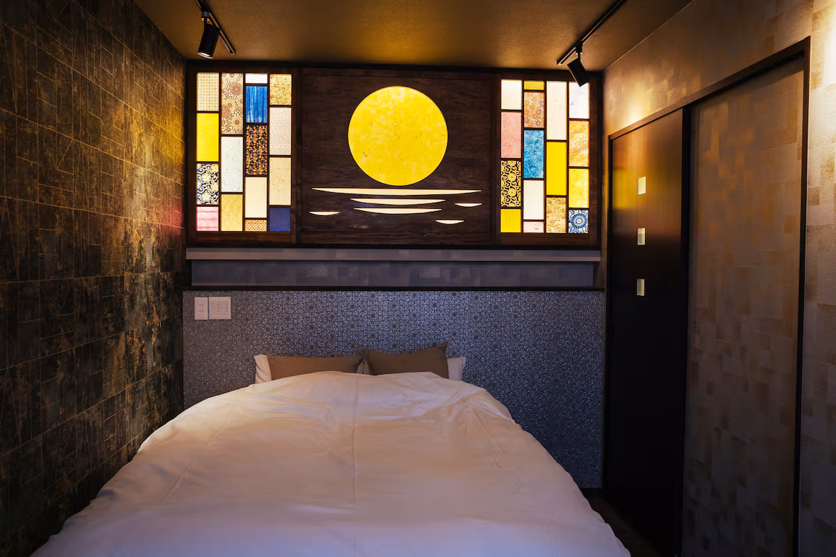 Double bed under a stained-glass full moon in Jin, a one-room hostel house in Nishijin, Kyoto