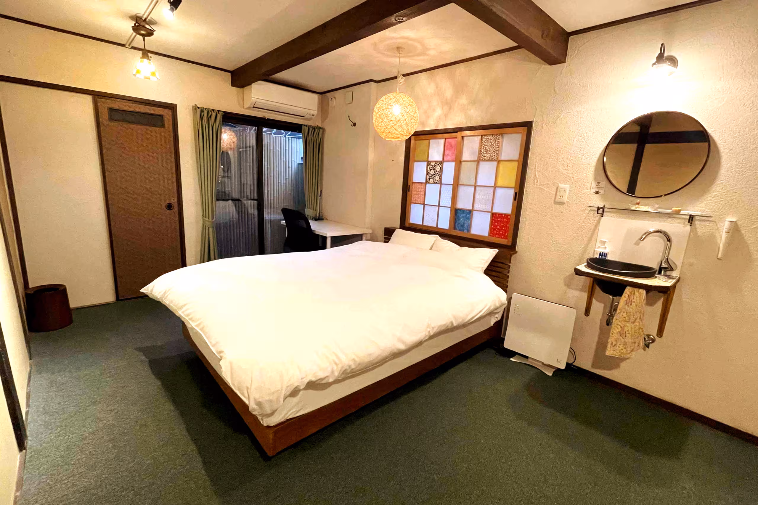 Kin, a private hostel room in Nishijin, Kyoto, with a double bed under a colourful paper shoji panel