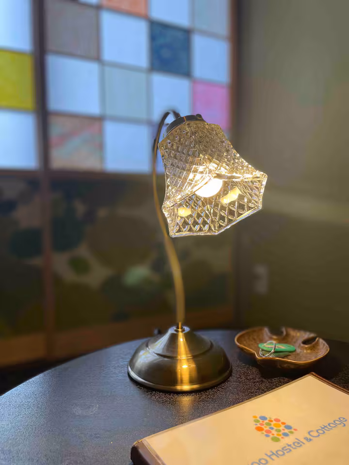 Glass desk lamp and room guide in Koke room, in front of the coloured shoji window