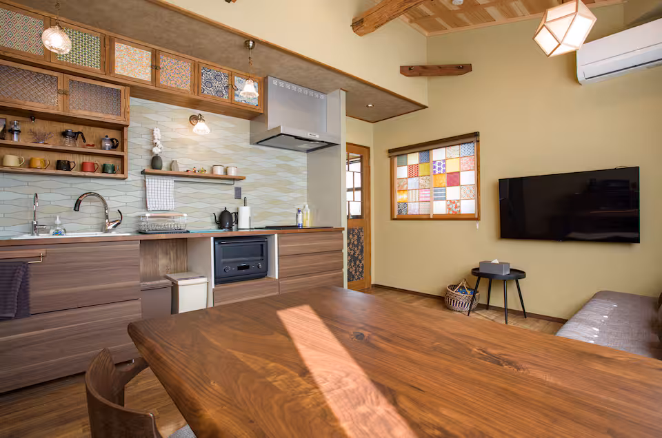 Sane cottage's sunny upstairs kitchen and living room with a long wooden table